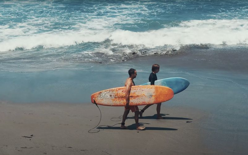 Walking the beach with the boards, Bali